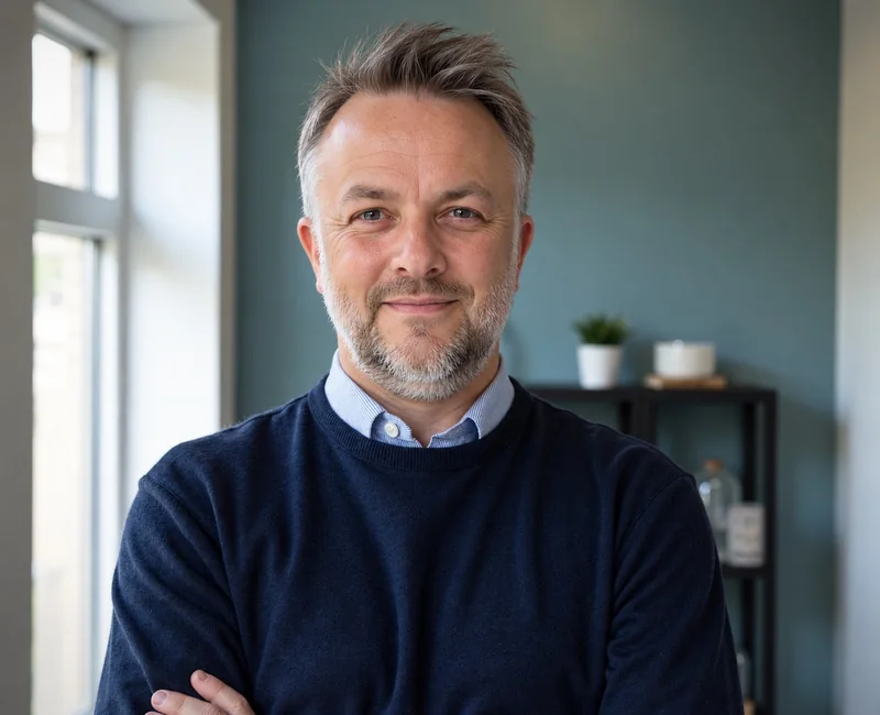 Andy Forrister, founder of AFWD, wearing a navy jumper by a window